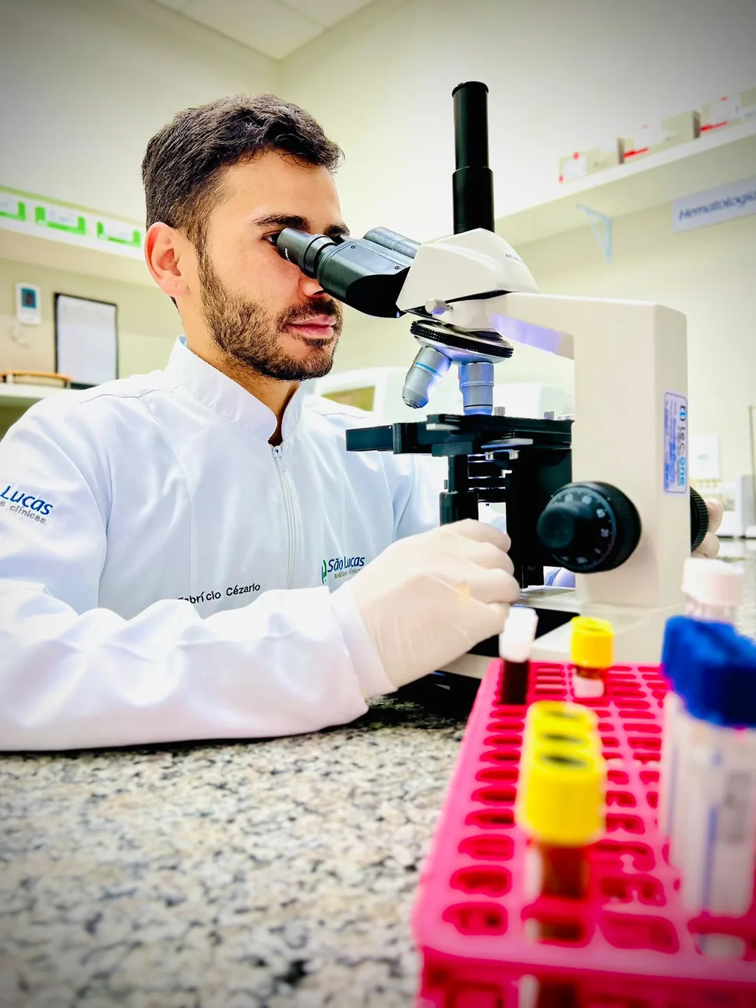 Profissional do São Lucas analisando amostra no microscópio